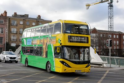 Image of a Green and Yellow Dublin Bus driving on the road