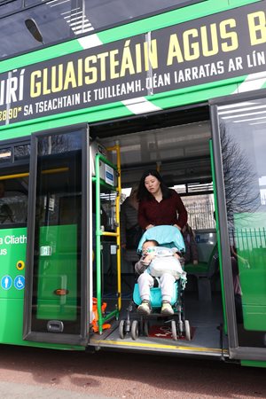 Woman alighting bus with buggy