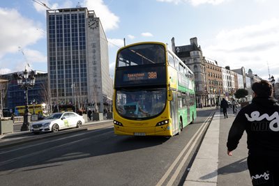 Dublin Bus driving on road in the green and yellow livery