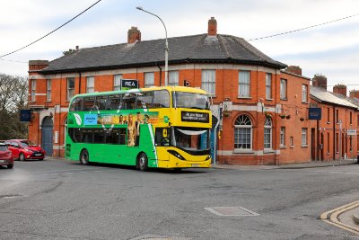Image of Dublin Bus driving with red car beside it.
