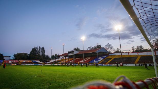 Tolka Park Soccer Stadium in dusk lighting with flood lights lit