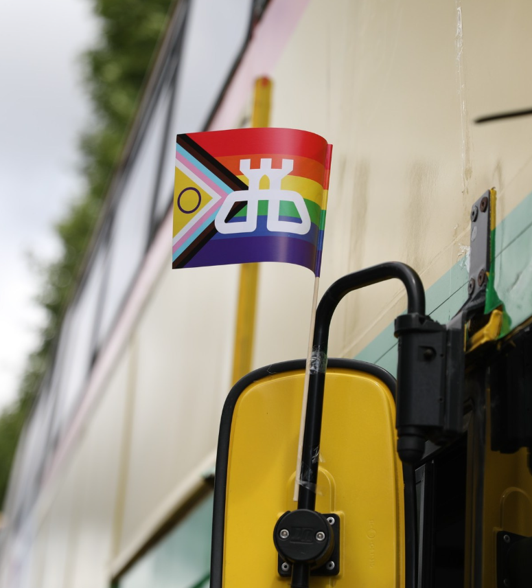 Image of Dublin Bus branded rainbow pride flag attached to vehicle wing mirror 