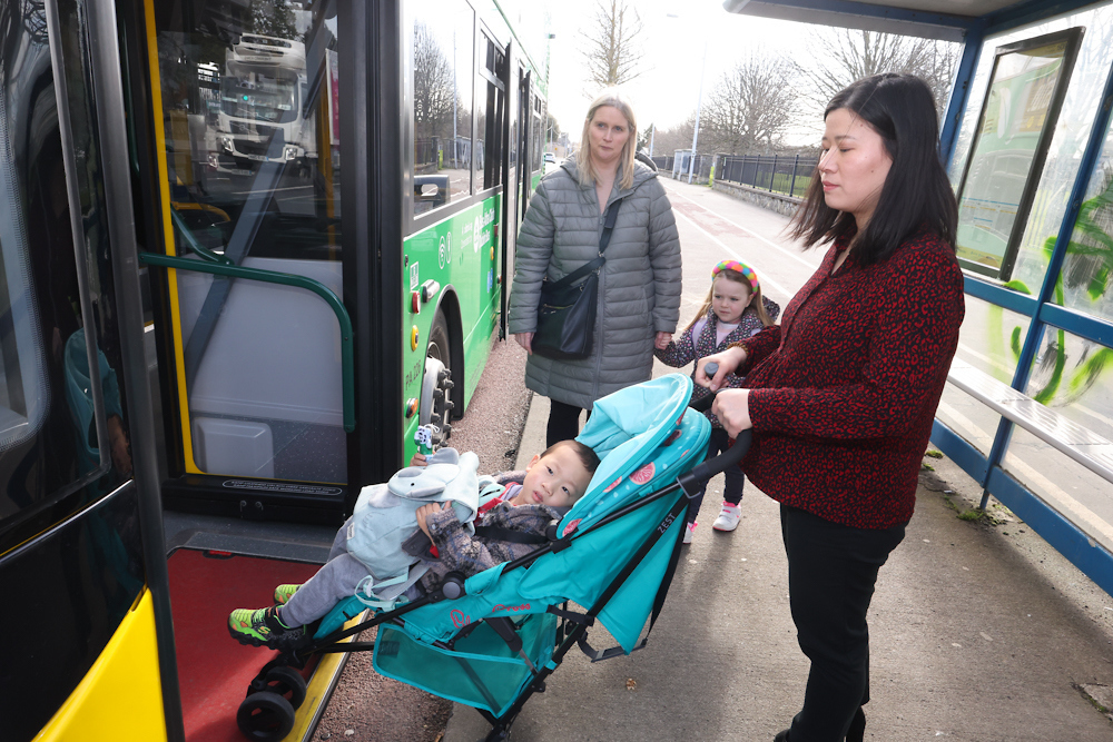 Image of customer boarding bus with buggy while another customer queues behind 
