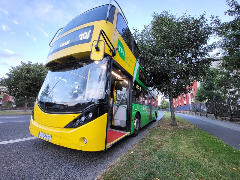 Side view of green and yellow bus parked
