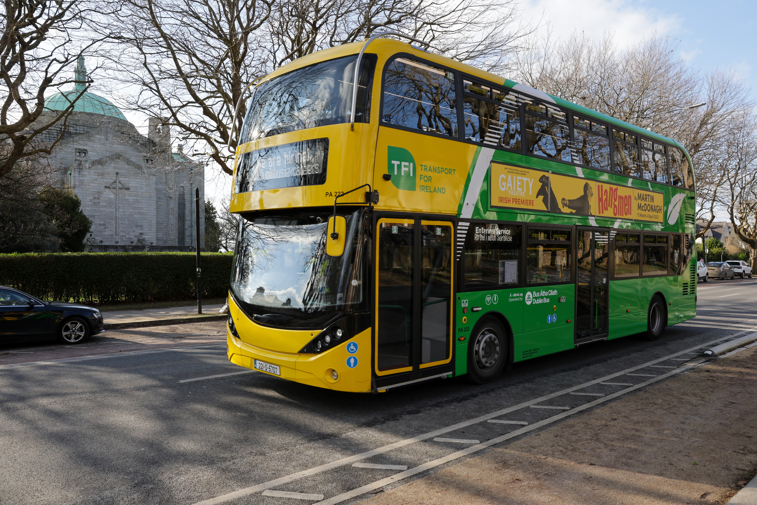 Image of yellow and green bus driving on the road