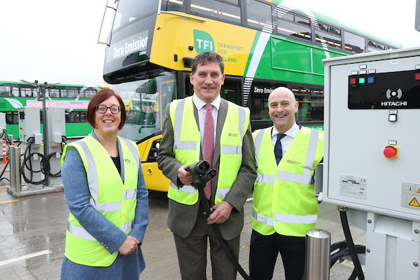 Anne Graham, Eamon Ryan and Billy Hand pose in Depot in front of electric bus