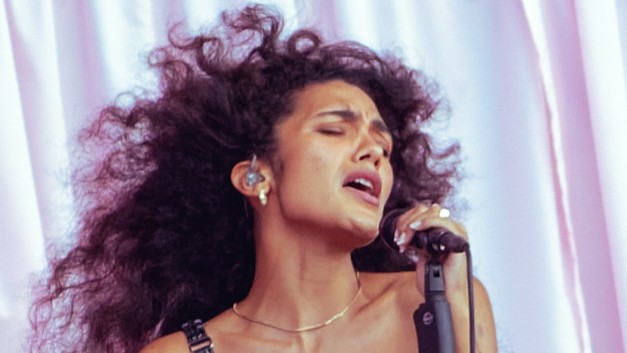Image of Olivia Dean singing on sage