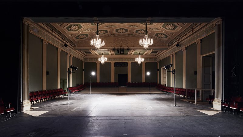 Dark image, with chandelier inside the Gate Theatre 