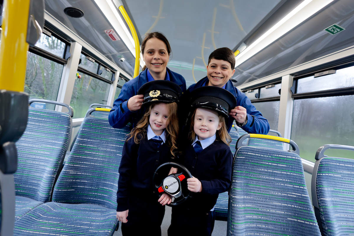 Image of two twin female drivers and twin girls on the bus