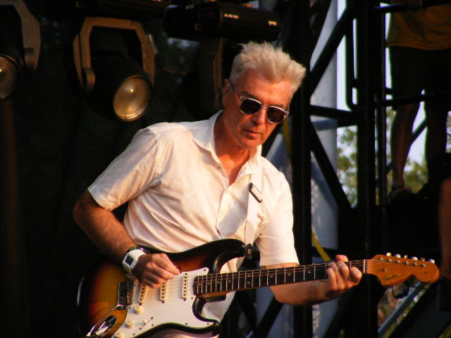 Image of David Byrne on sage playing guitar