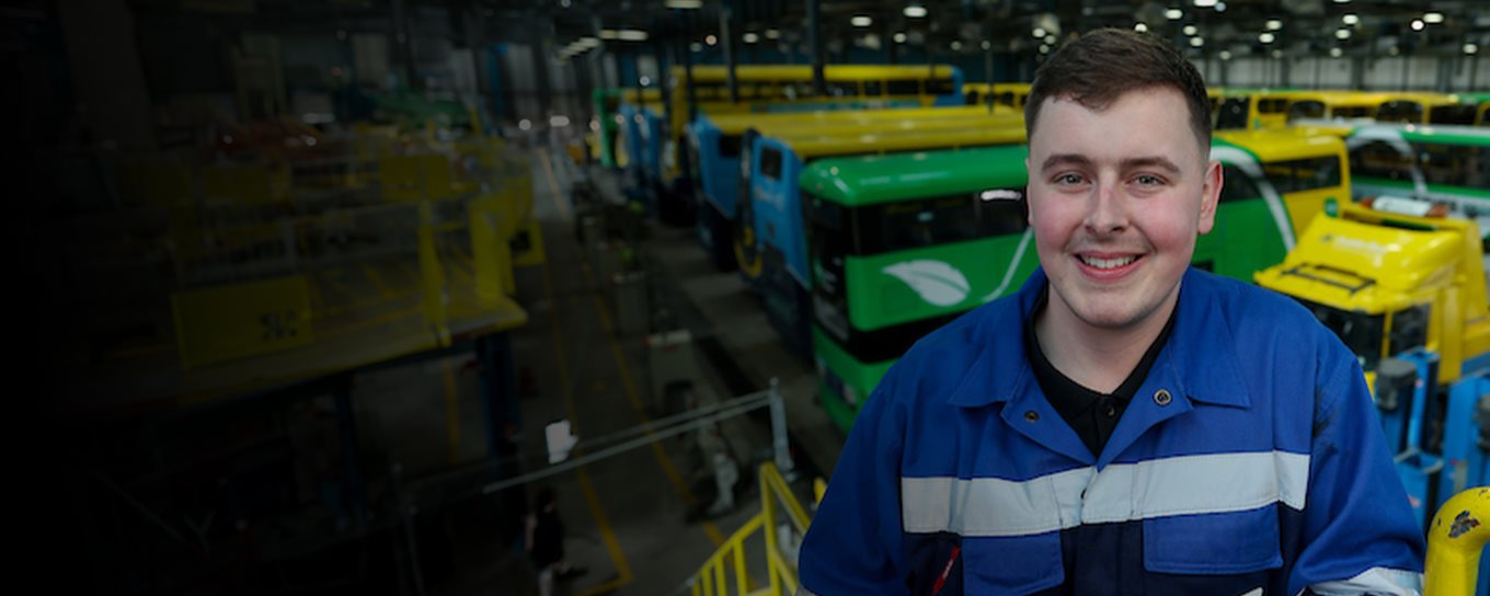 Mechanic in bus depot with buses in the background